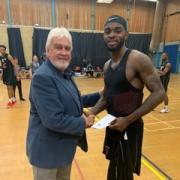 Rockets Chairman Gary Johnson presents player of the game Nick Richards with his award following his 30 points and eight rebounds