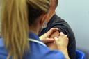 Mark Nicolls receives an injection of the Moderna Covid-19 vaccine administered by nurse Amy Nash, at the Madejski Stadium in Reading, Berkshire.