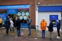 People queue at a vaccination centre on Solihull High Street, West Midlands, as the coronavirus booster vaccination programme is ramped up