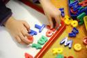 A child at play with an alphabet toy. Credit: Dominic Lipinski/PA Wire