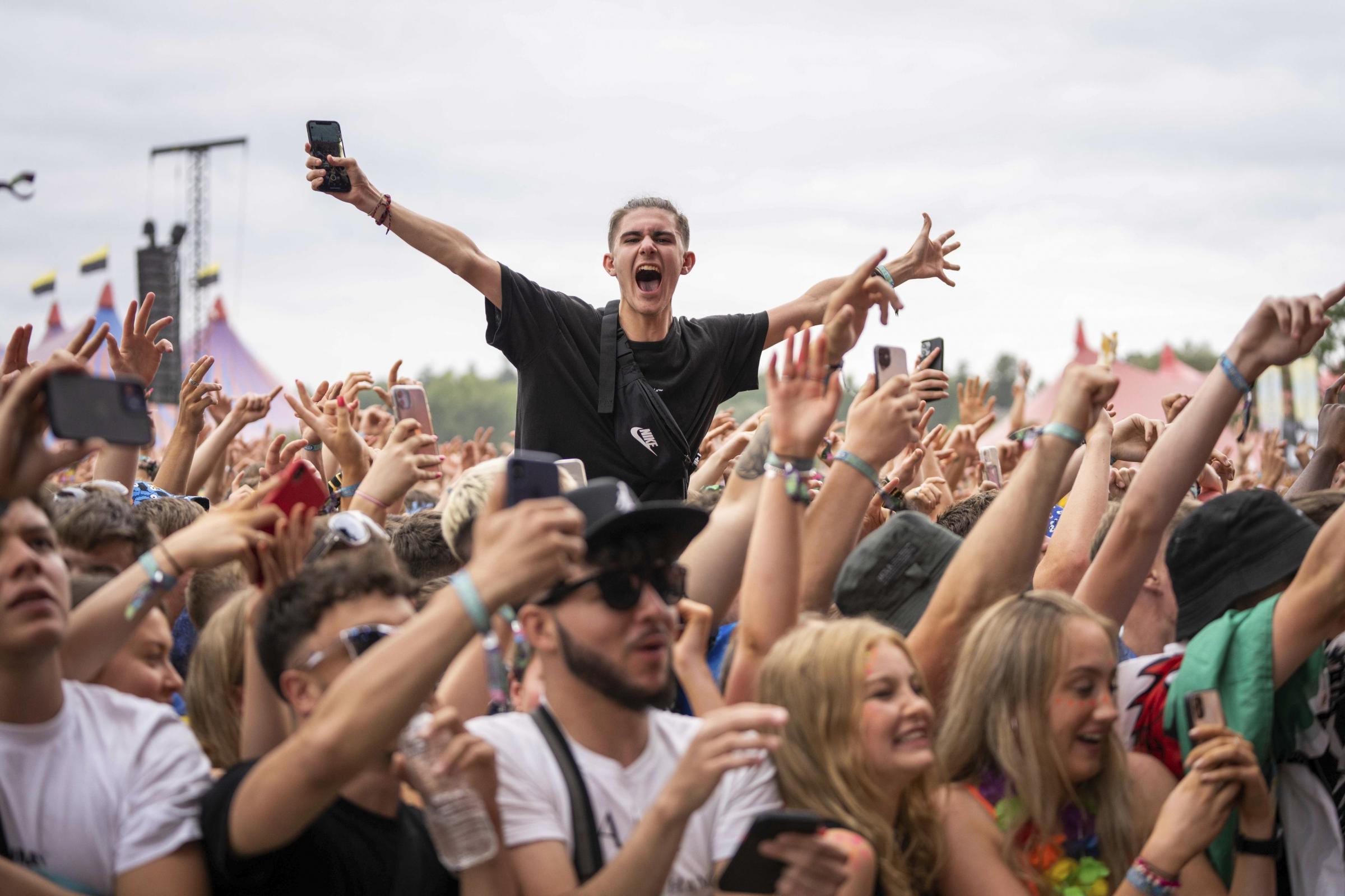 Members of the public cheer at the Main Stage of Reading Music Festival, in Reading, England, Friday, Aug. 27, 2021. (AP Photo/Scott Garfitt).