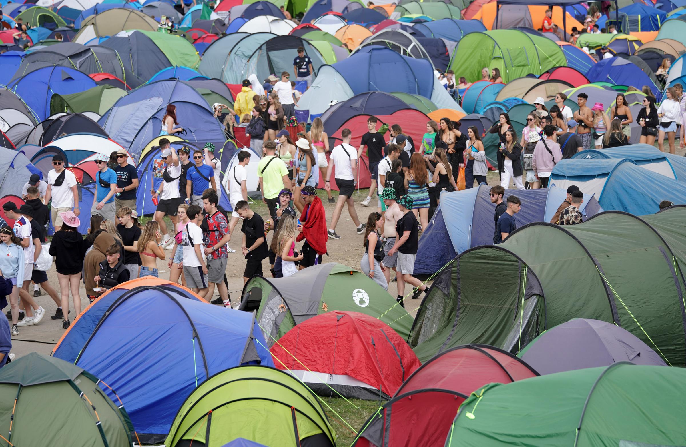 Festival goers walk past tents at the Reading Festival at Richfield Avenue. Picture date: Thursday August 26, 2021. PA Photo. Photo credit should read: Kirsty OConnor/PA Wire.