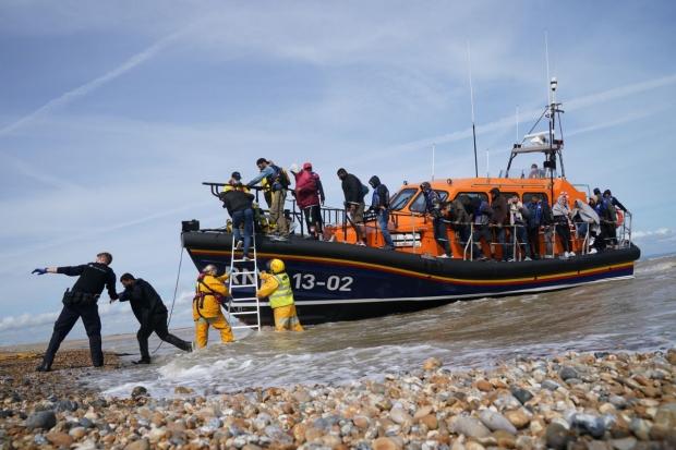 File photo dated 13/09/21 of Immigration Enforcement officers and members of the RNLI assisting a group of people thought to be migrants from an RNLI lifeboat in Dungeness, Kent.