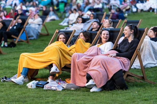 4 girls sitting with blankets at an outdoor cinema. Credit: Adventure Cinema