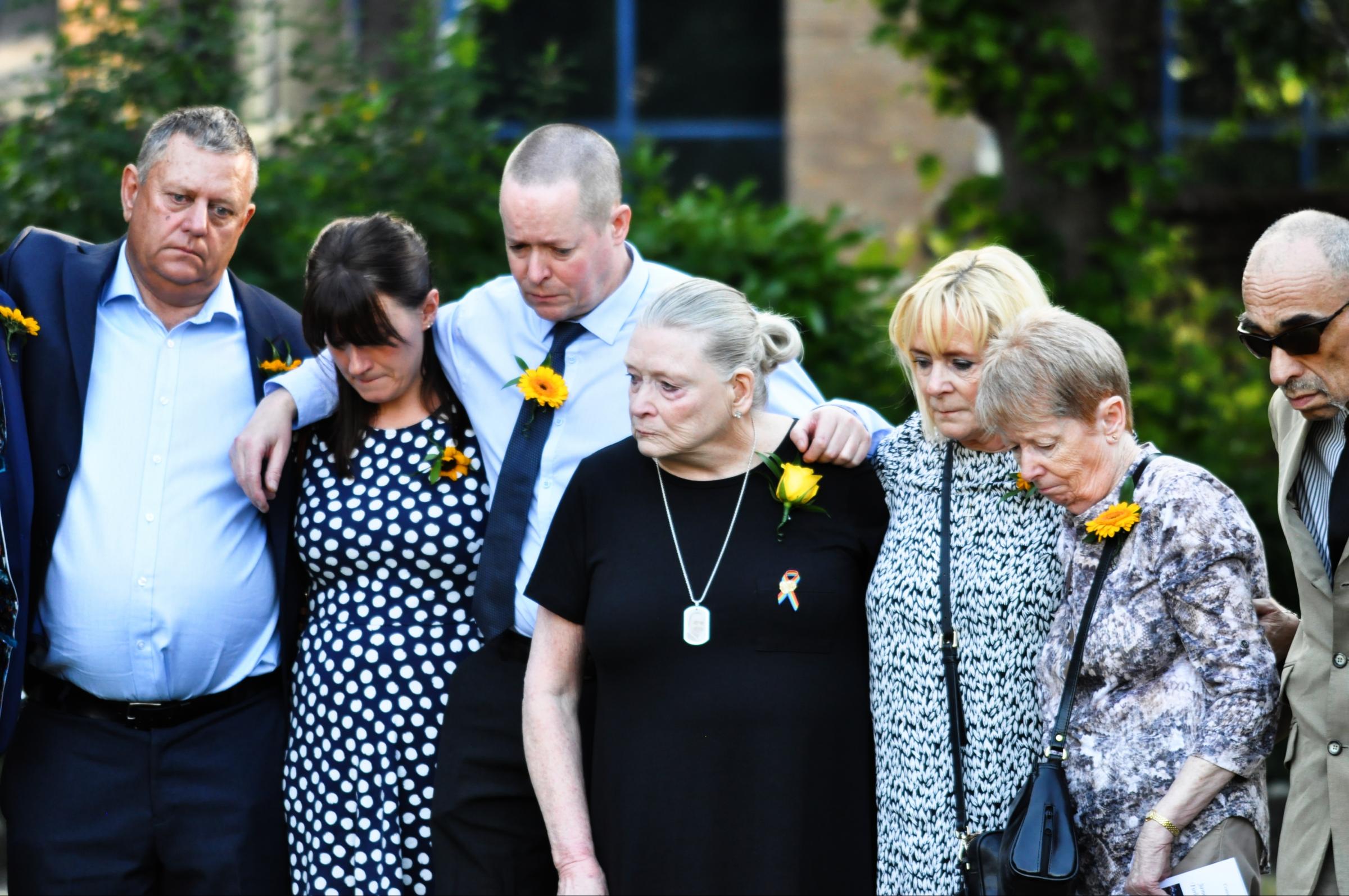 Gary Furlong (far left) and family members pay respect to the victims