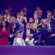 The Princess of Wales, Princess Charlotte, Prince George and the Prince of Wales playing with a Union Flag in the Royal Box at the Coronation Concert held in the grounds of Windsor Castle, Berkshire